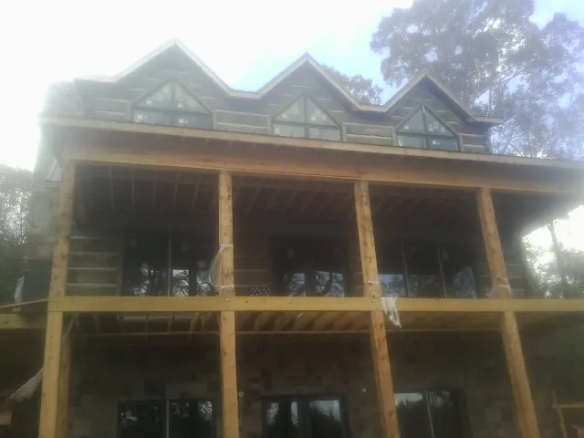 Dormers and porch framing on a large log home under construction — Roof Coating work by our crew in Nanticoke