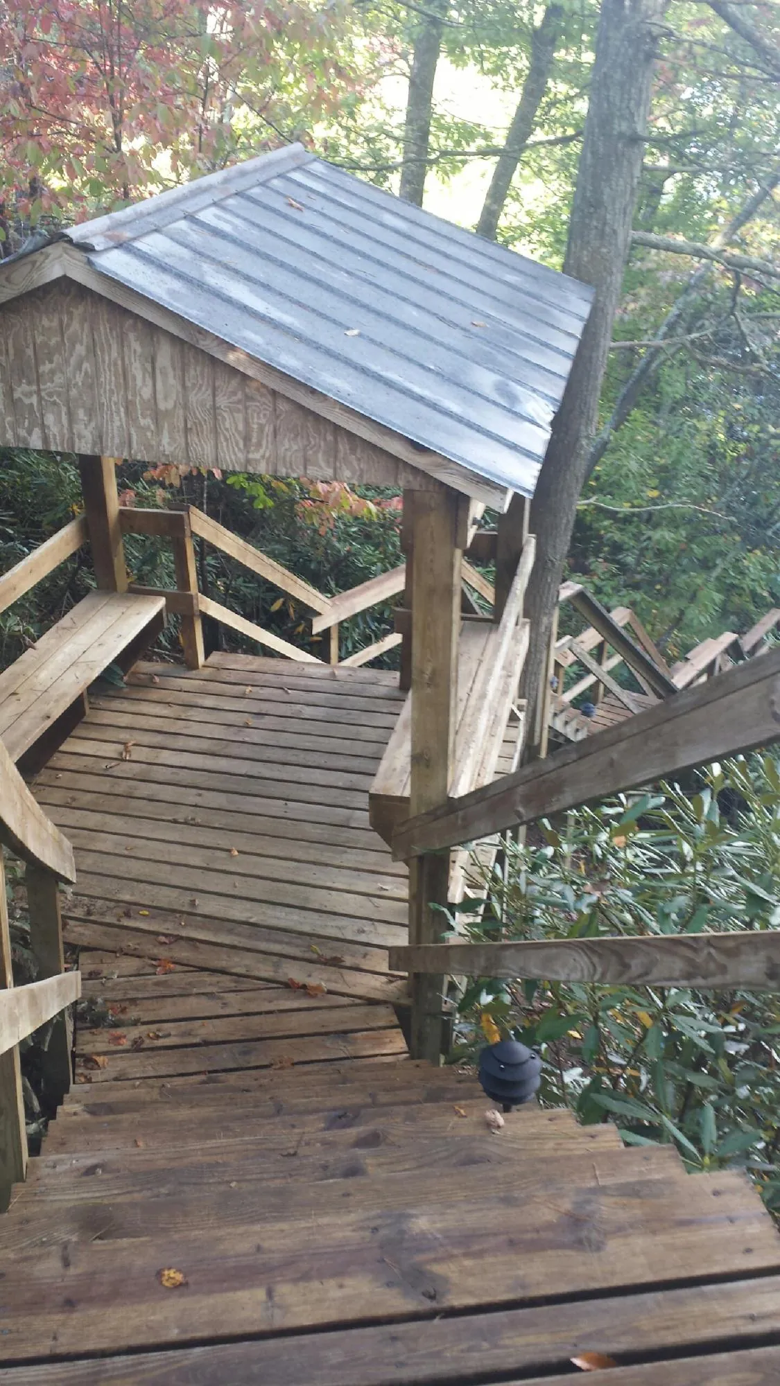 Metal roofed shelter over wooden steps on a wooded walkway — Skylight Repair & Installation work by our crew in Nanticoke