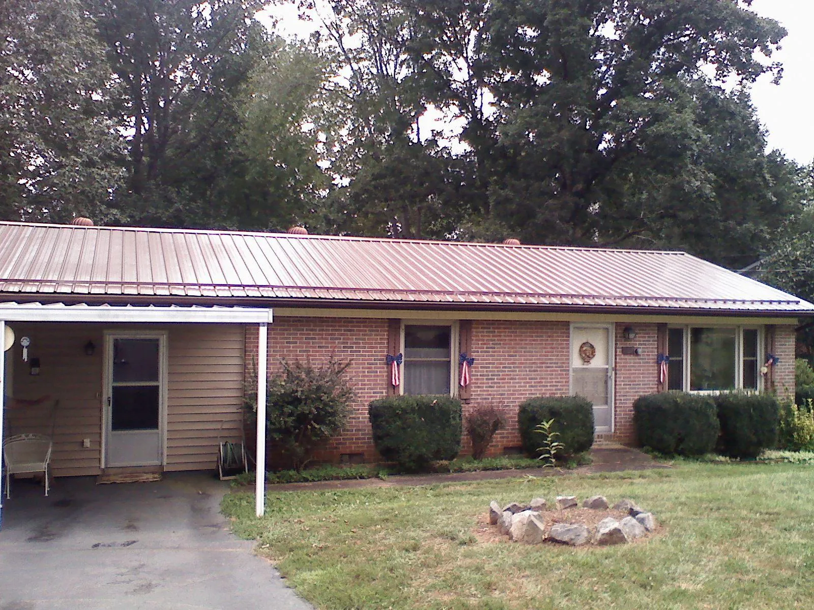 Bronze metal roof and carport on a brick ranch home — Roof Repair work by our crew in Nanticoke